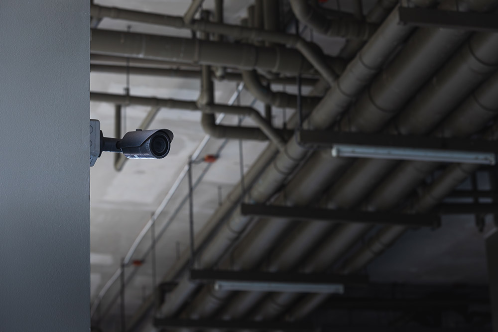 primer plano de cctv en el edificio de estacionamiento con el fondo del sistema de tuberias de agua